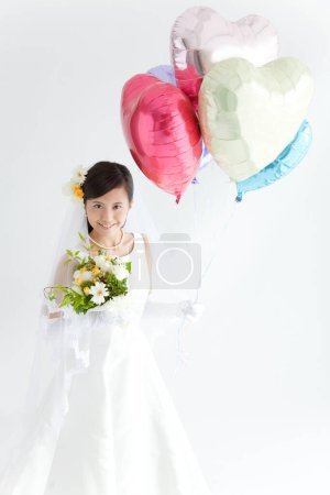 Photo for A bride holding a bunch of balloons - Royalty Free Image