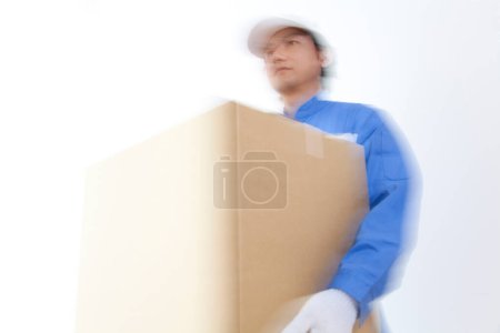 Photo for Young Japanese delivery man with cardboard box - Royalty Free Image