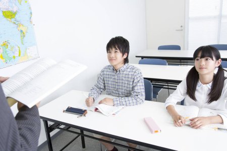 Photo for Portrait of Japanese girl and boy studying with teacher in school - Royalty Free Image