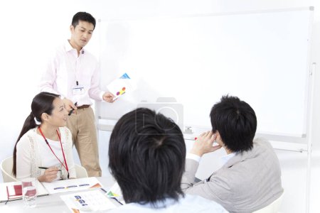 Foto de Grupo de jóvenes japoneses equipo de negocios discutiendo proyecto. concepto de trabajo en equipo - Imagen libre de derechos