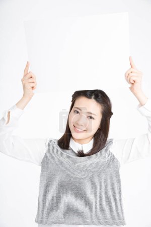 Téléchargez les photos : Portrait studio de belle femme japonaise tenant tableau blanc vierge - en image libre de droit