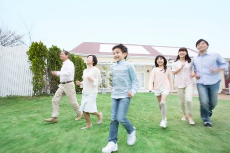 Téléchargez les photos : Portrait de grande famille japonaise courant près de la maison - en image libre de droit