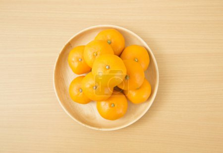 Téléchargez les photos : Mandarines mûres sur une assiette sur la table - en image libre de droit