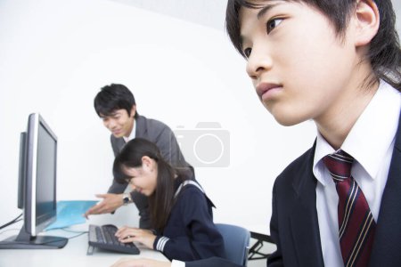 Photo for Portrait of Japanese girl and boy studying with teacher in school - Royalty Free Image