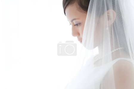 Foto de Una mujer en un vestido de novia mirando hacia abajo - Imagen libre de derechos