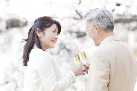 Photo for Portrait of senior couple toasting with wine in park - Royalty Free Image