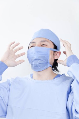 Téléchargez les photos : Portrait jeune homme asiatique portant un masque chirurgical, isolé sur fond blanc - en image libre de droit