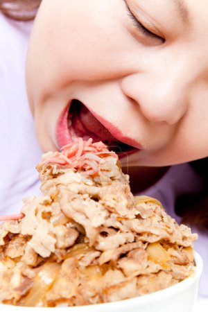 Téléchargez les photos : Femme asiatique en surpoids mangeant de la viande. portrait studio - en image libre de droit