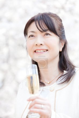 Photo for Young woman drinking champagne in park - Royalty Free Image