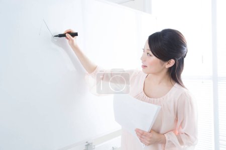Photo for Portrait of an asian woman teacher writing on white board - Royalty Free Image