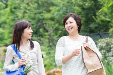 Foto de Sonrientes mujeres japonesas hablando en el parque de verano - Imagen libre de derechos