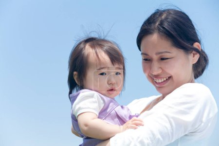 Photo for Happy Japanese mother and child spending time together during sunny day - Royalty Free Image