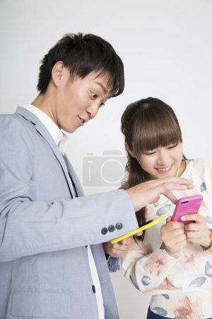 Photo for Young couple using smart phones in studio - Royalty Free Image