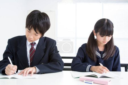 Foto de Estudiantes japoneses sentados en el aula durante la lección, fondo blanco - Imagen libre de derechos