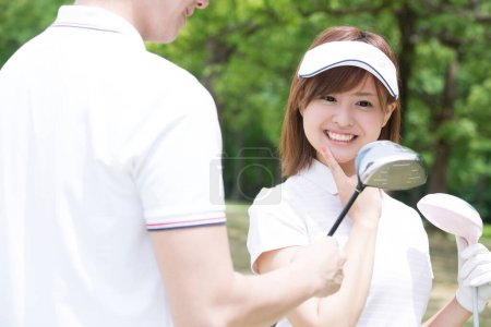 Téléchargez les photos : Jeune femme et homme joueurs de golf - en image libre de droit