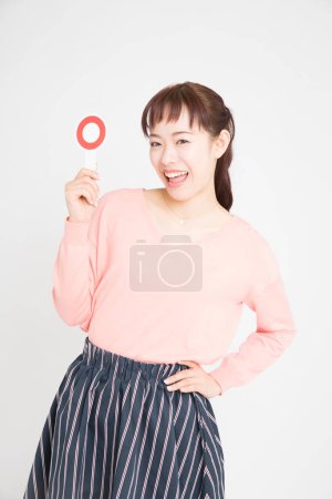 Foto de Mujer joven mostrando signo de círculo rojo. Chica japonesa con cartel OK - Imagen libre de derechos