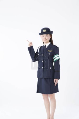 Photo for Studio portrait of Japanese female police officer pointing - Royalty Free Image