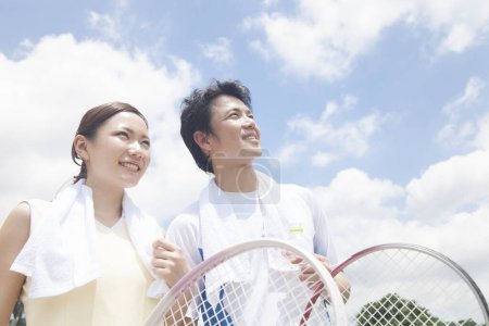 Téléchargez les photos : Jeune couple avec raquettes de tennis en plein air - en image libre de droit