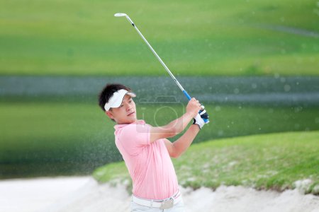 Téléchargez les photos : Golfeur sur un terrain de golf jouant au golf par belle journée ensoleillée - en image libre de droit