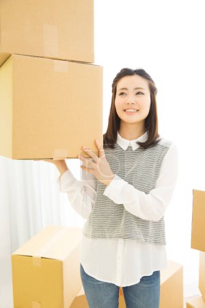 Photo for Beautiful Japanese woman with cardboard boxes at home - Royalty Free Image
