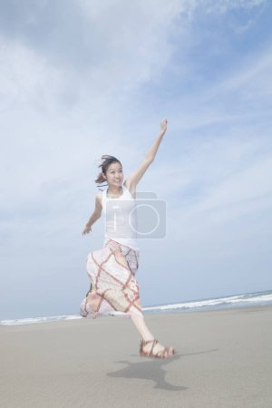 Foto de Mujer corriendo en la playa con el cielo azul - Imagen libre de derechos