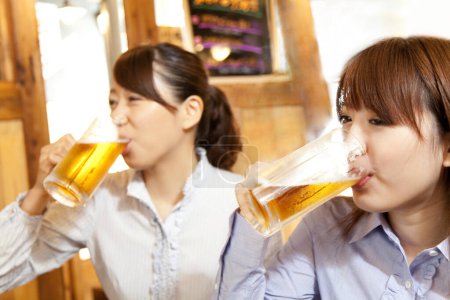 Téléchargez les photos : Deux femmes buvant de la bière dans un restaurant - en image libre de droit