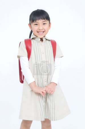 Téléchargez les photos : Portrait studio de mignonne fille japonaise avec sac à dos - en image libre de droit