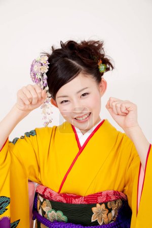 Photo for Portrait of japanese girl in kimono showing fists - Royalty Free Image