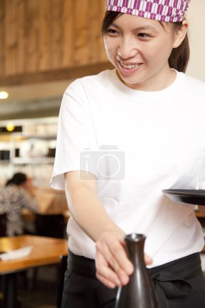 Photo for Young waitress serving dish - Royalty Free Image