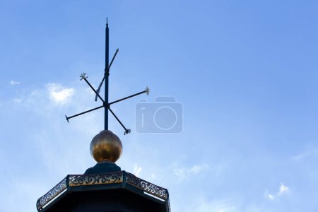 Clack veleta meteorológica colocada en un techo, fondo cielo nublado 
