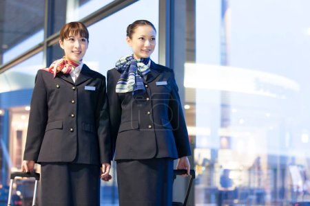 Photo for Two beautiful Japanese flight attendants in airport - Royalty Free Image