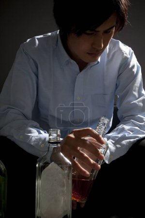 Photo for Young asian male drinking whiskey - Royalty Free Image
