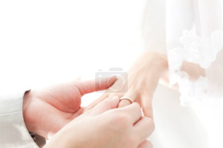 Photo for A person putting a wedding ring on a person's finger - Royalty Free Image