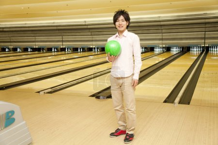 Téléchargez les photos : Asiatique homme tenant boule de bowling au club - en image libre de droit