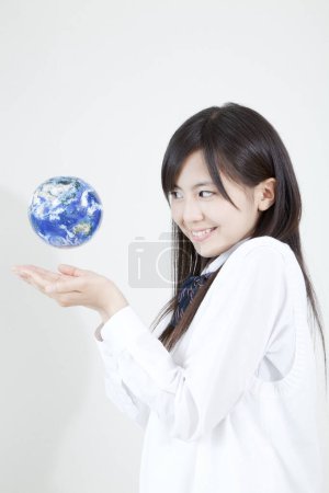 Téléchargez les photos : Portrait studio de jeune fille japonaise avec globe mondial - en image libre de droit