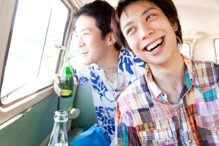 Foto de Dos amigos felices disfrutando de la cerveza en el coche - Imagen libre de derechos