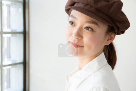 Téléchargez les photos : Portrait de jeune belle serveuse japonaise en béret marron - en image libre de droit