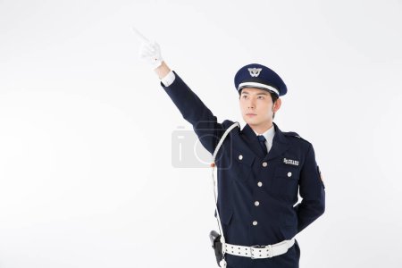 Photo for Studio portrait of Japanese police officer in uniform pointing - Royalty Free Image
