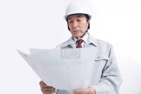 Téléchargez les photos : Asiatique ingénieur homme tenant papiers - en image libre de droit