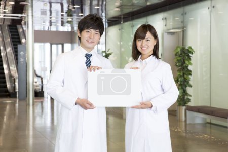 Photo for Young and confident asian medical team holding a white board - Royalty Free Image