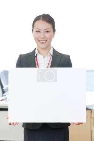 Photo for Portrait of a businesswoman showing a blank sign in office - Royalty Free Image