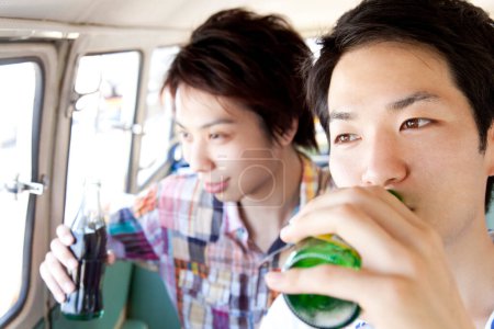 Téléchargez les photos : Jeunes hommes buvant dans une voiture - en image libre de droit