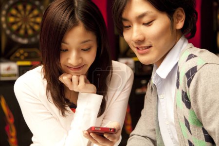 Téléchargez les photos : Jeune couple jouant jeu mobile - en image libre de droit