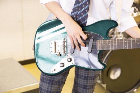 Foto de Niño de la escuela tocando la guitarra eléctrica en clase, vista de cerca - Imagen libre de derechos