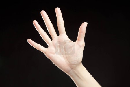 Téléchargez les photos : Gros plan de la main de la femme montrant un geste sur fond noir - en image libre de droit