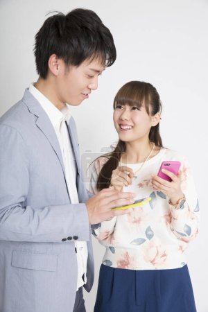 Photo for Young business couple using smartphones, studio shot - Royalty Free Image