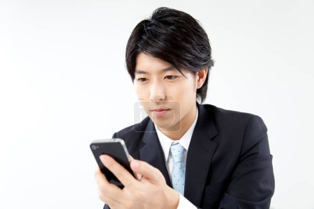 Téléchargez les photos : Asiatique homme d'affaires avec téléphone mobile isolé sur fond blanc - en image libre de droit