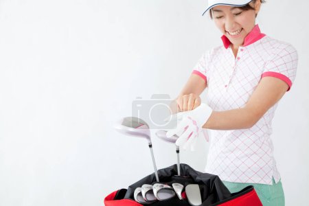 Foto de Joven mujer japonesa golfista con bolsa roja - Imagen libre de derechos