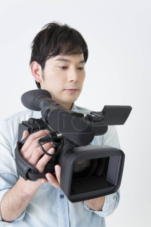 Photo for Young asian man with video camera - Royalty Free Image