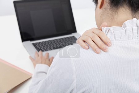Photo for Woman with backache  using laptop computer - Royalty Free Image